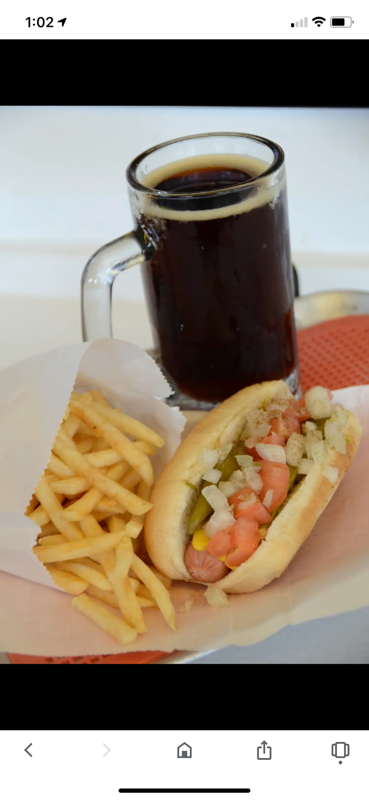 a close up of a hot dog next to a cup of coffee