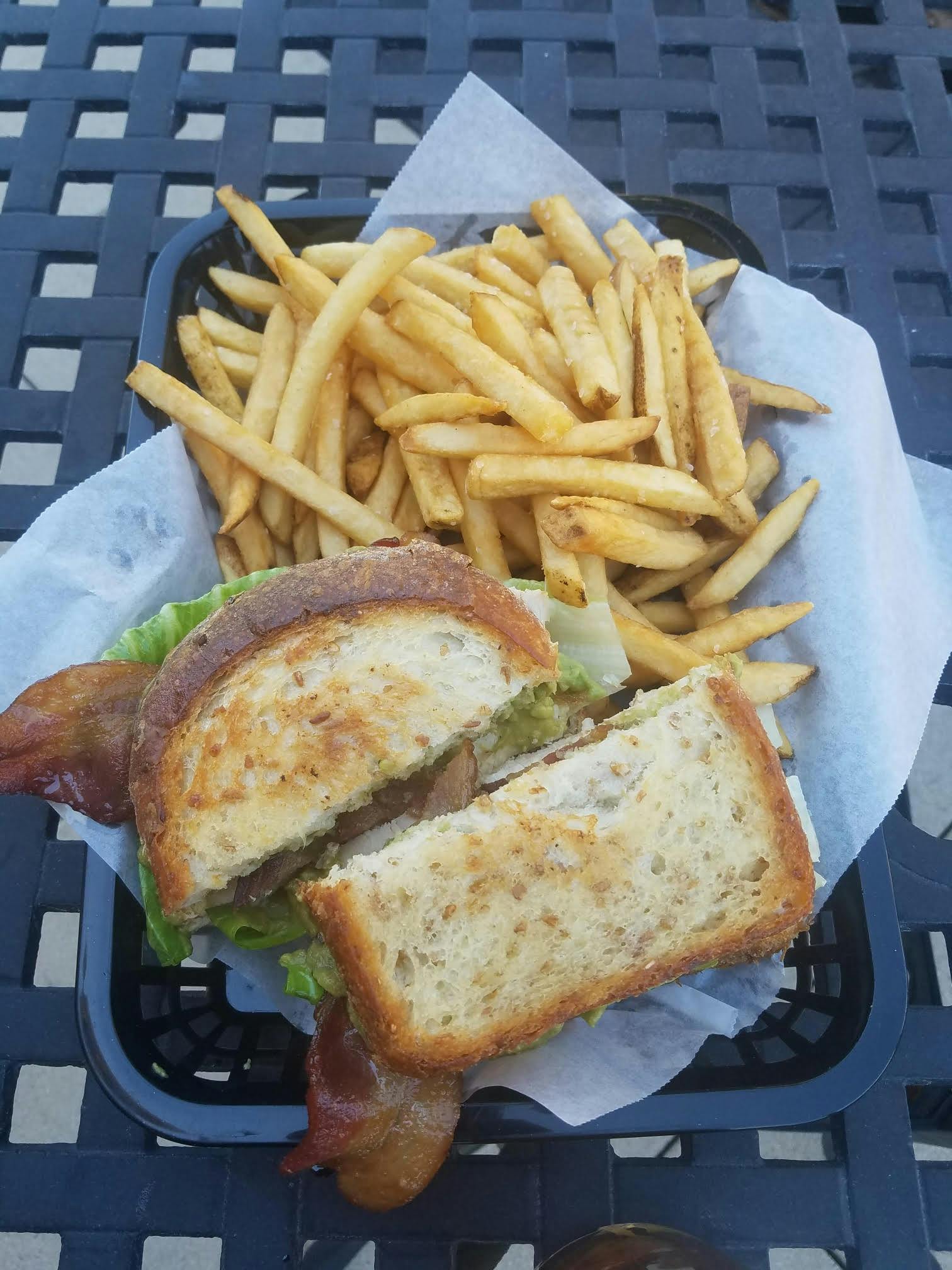 a sandwich sitting on top of a pile of fries
