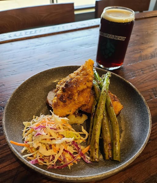 a plate of food and a glass of beer on a table