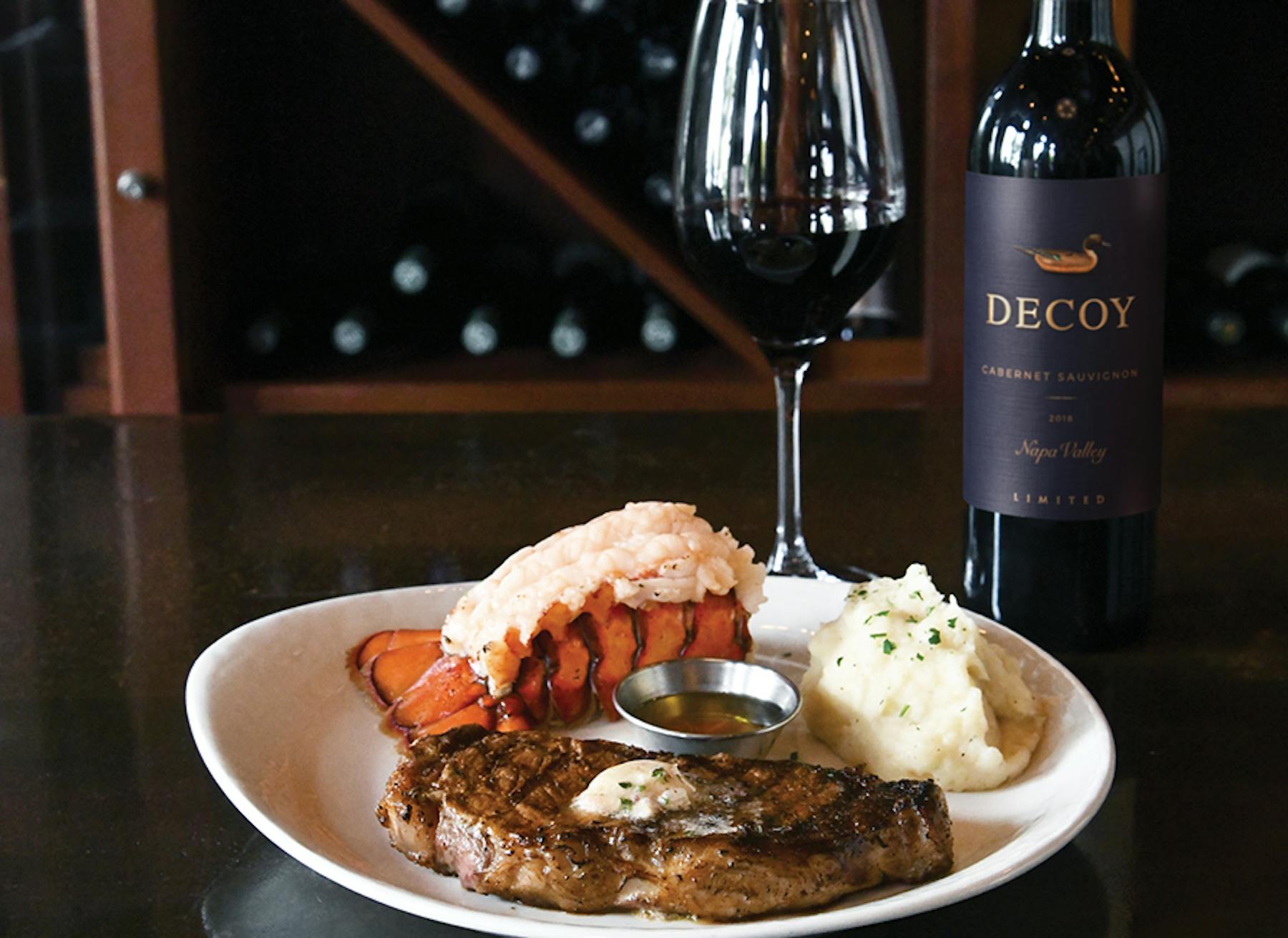 a plate of food and a bottle of wine on a table