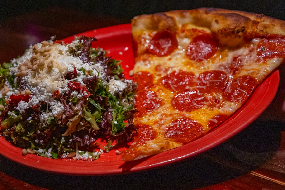 a plate of food with a slice of pizza