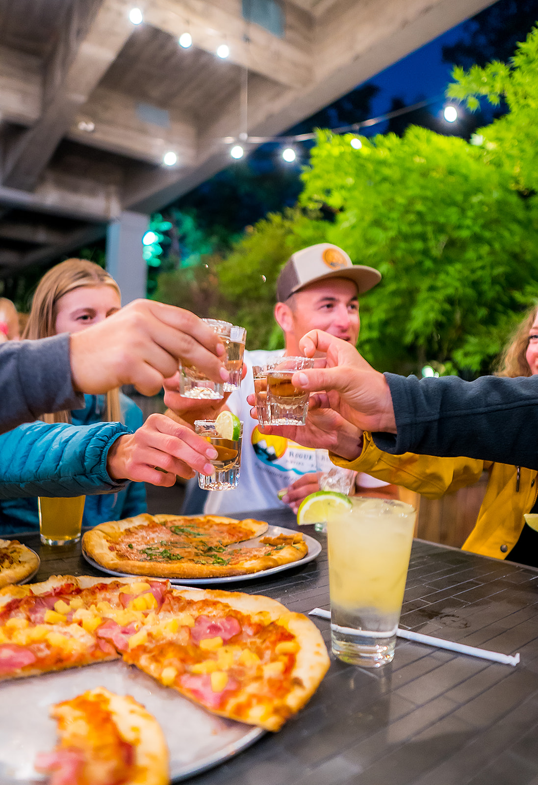 a group of people sitting at a table eating pizza