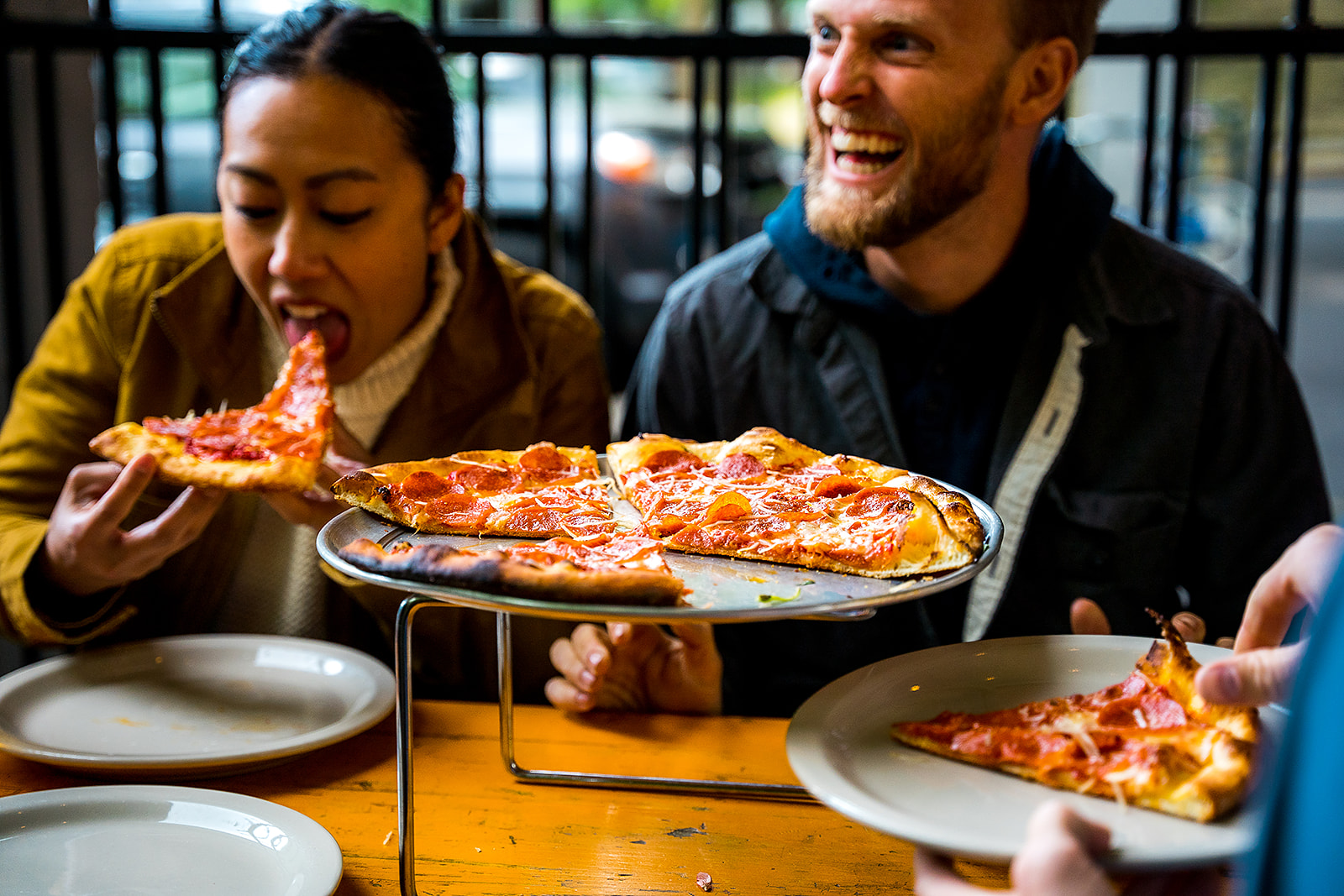 a man sitting at a table with a plate of pizza