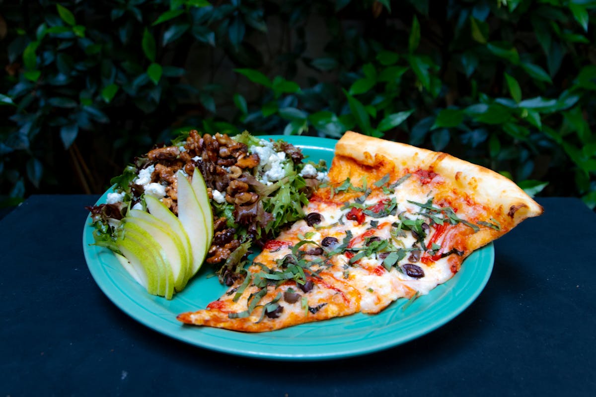 a plate of food with a slice of pizza