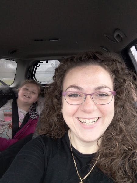 a woman wearing glasses and smiling at the camera