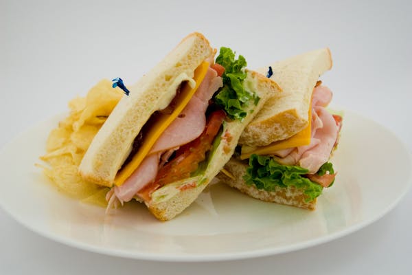 a white plate topped with a sandwich cut in half sided with french fries