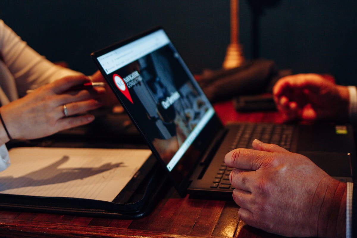 a person sitting at a table using a laptop computer