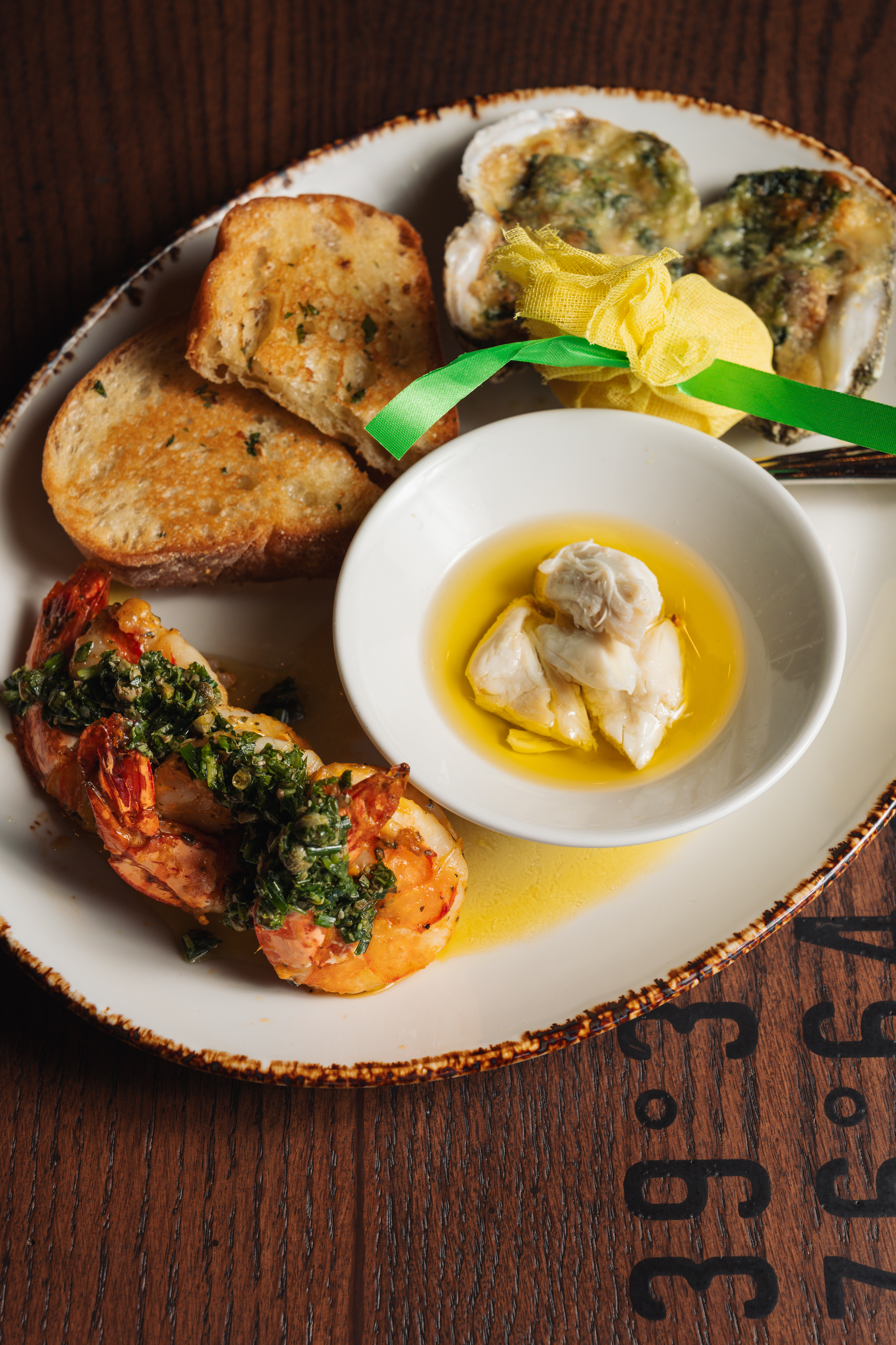 a plate of food with a small bowl of butter and a small white bowl of bread