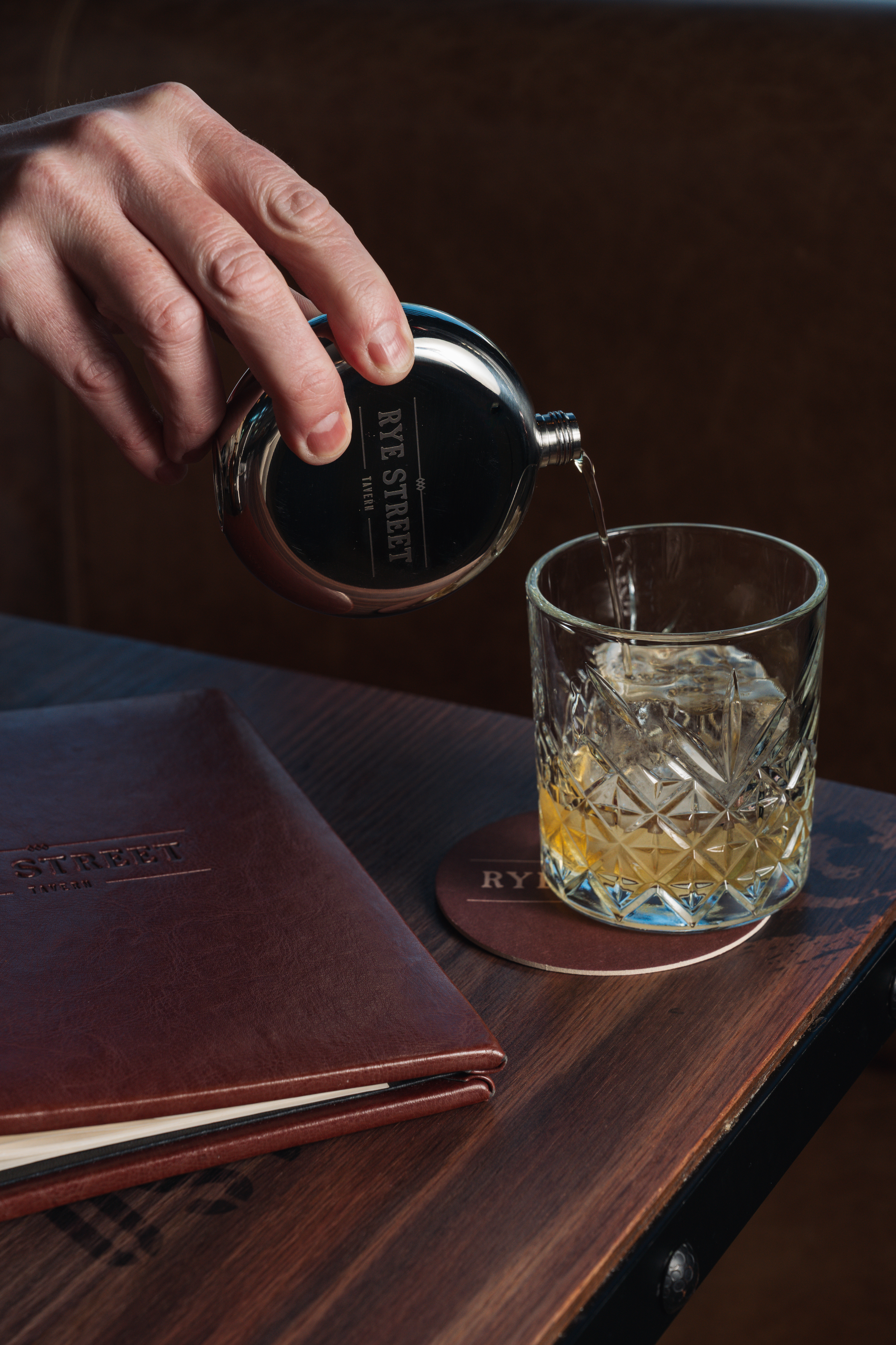 a hand pouring a drink into a glass