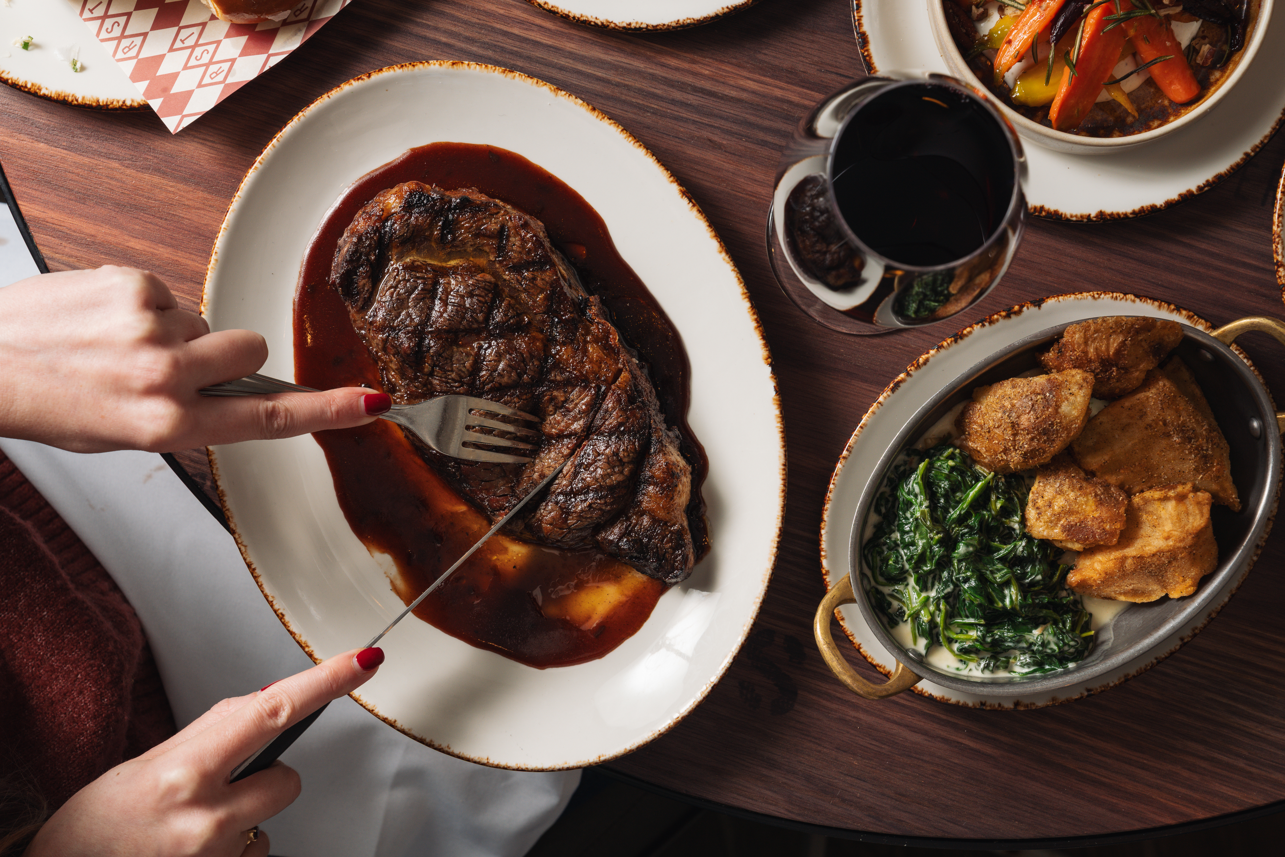 a person eating a steak with sauce on a plate