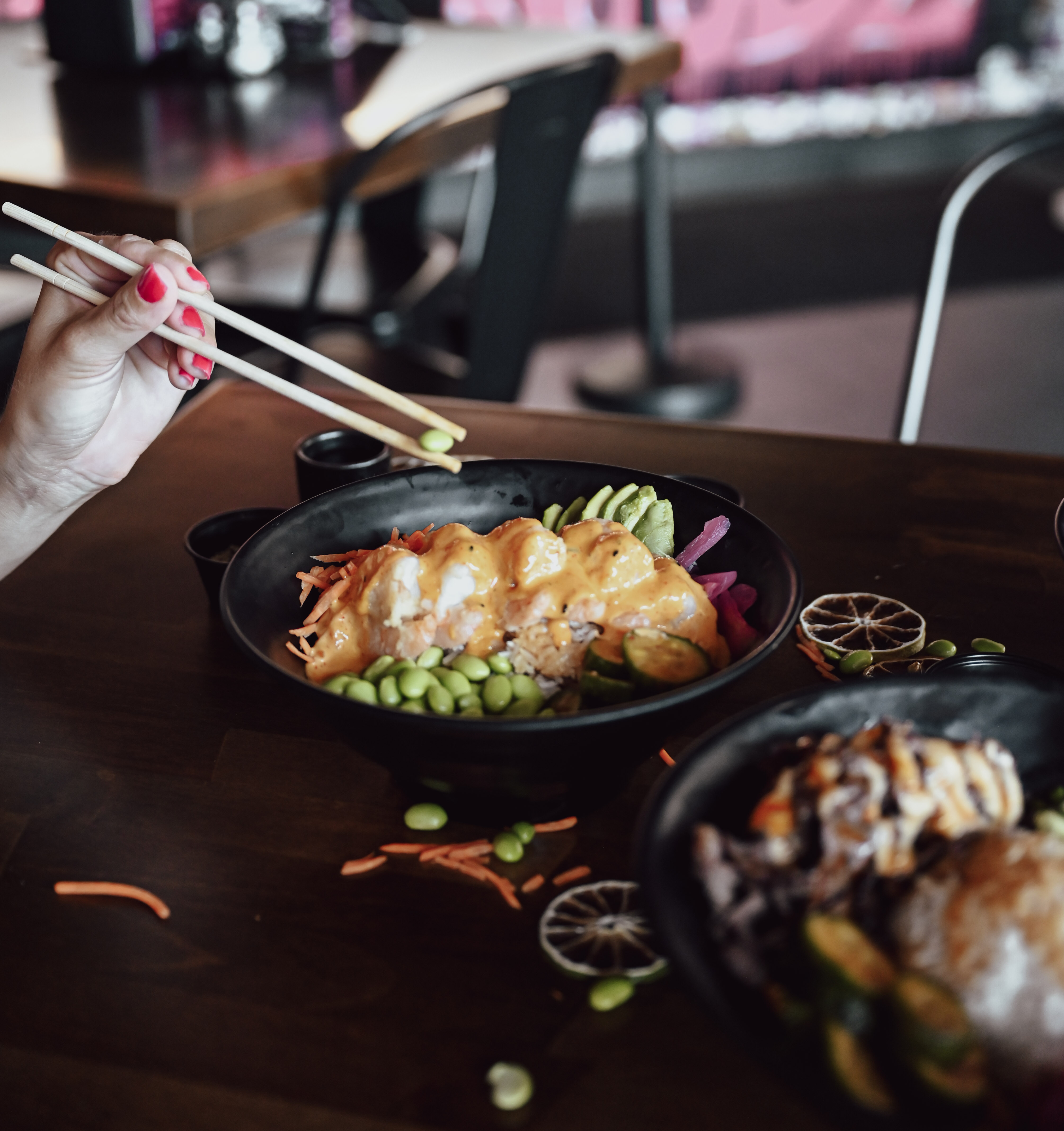 a person holding chopsticks over a bowl of food