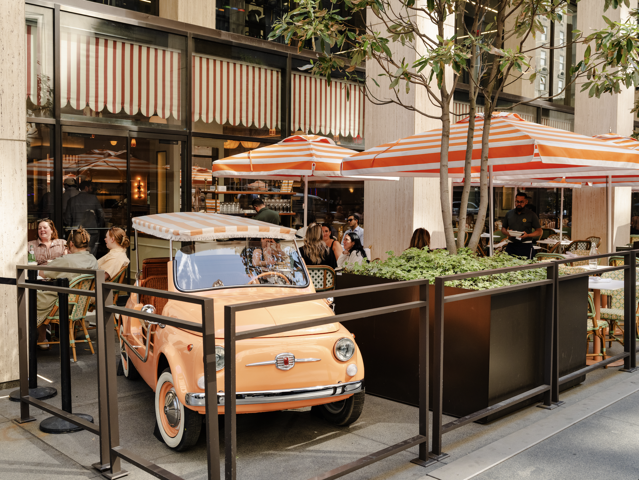 a small orange car parked outside a restaurant