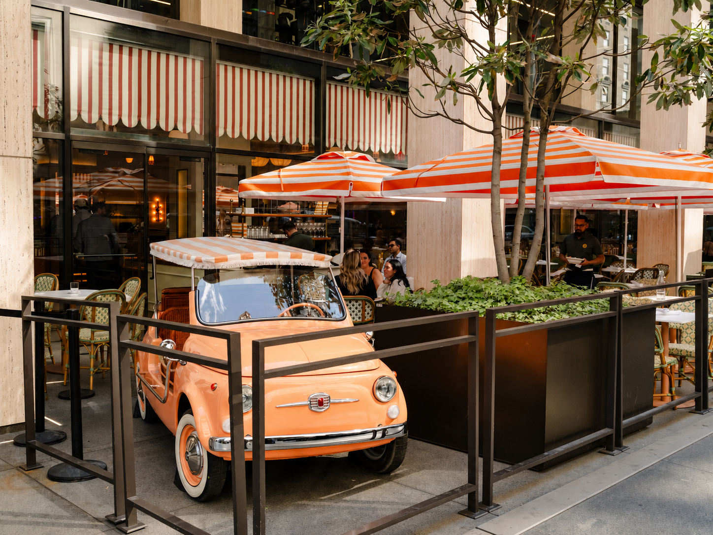 a small orange car parked outside a restaurant