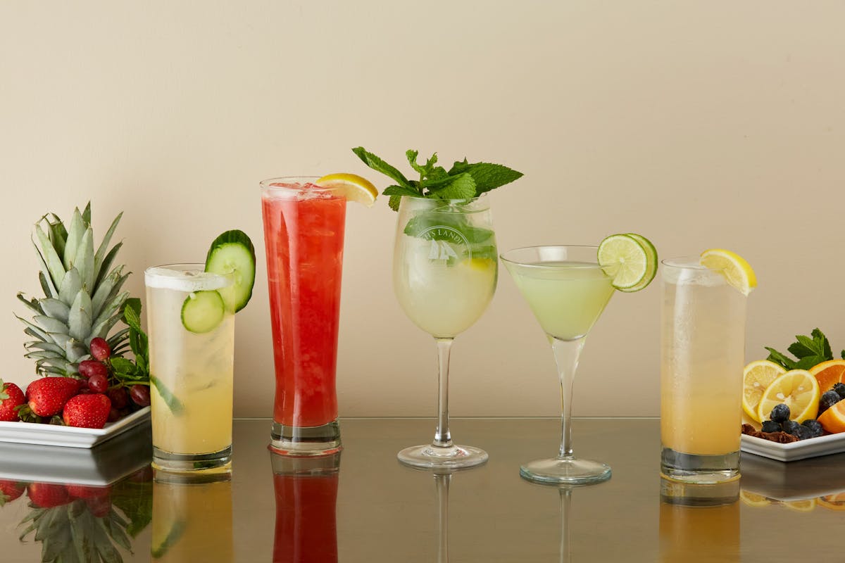 line up of various mixed cocktails on a table