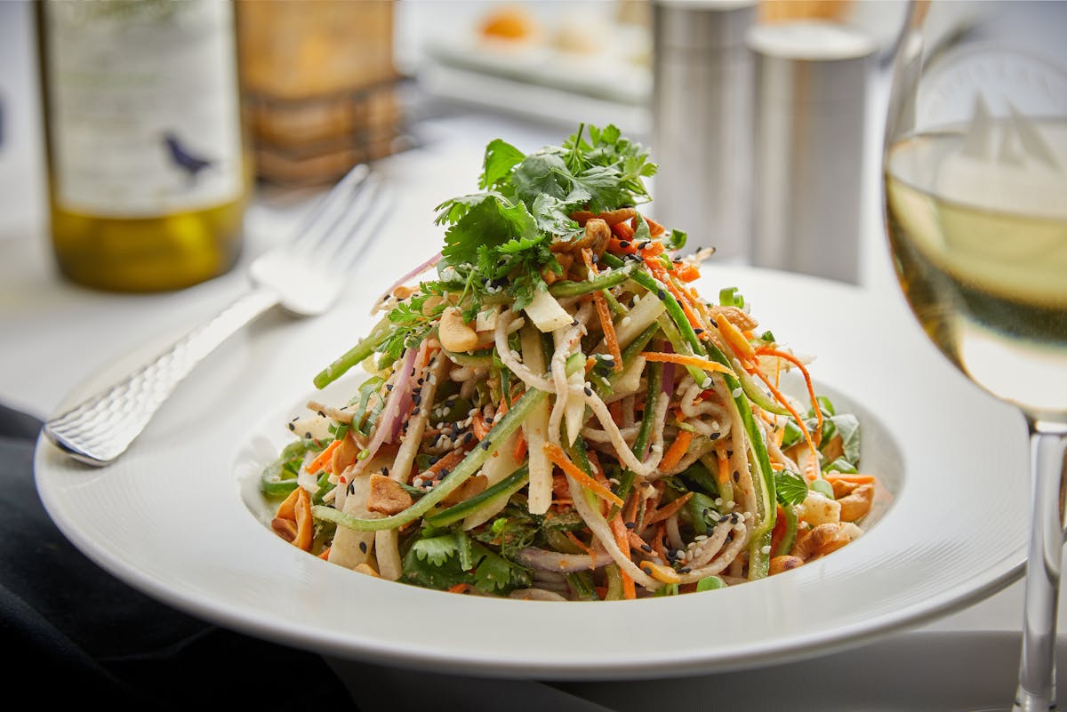 a plate of salad and a glass of wine