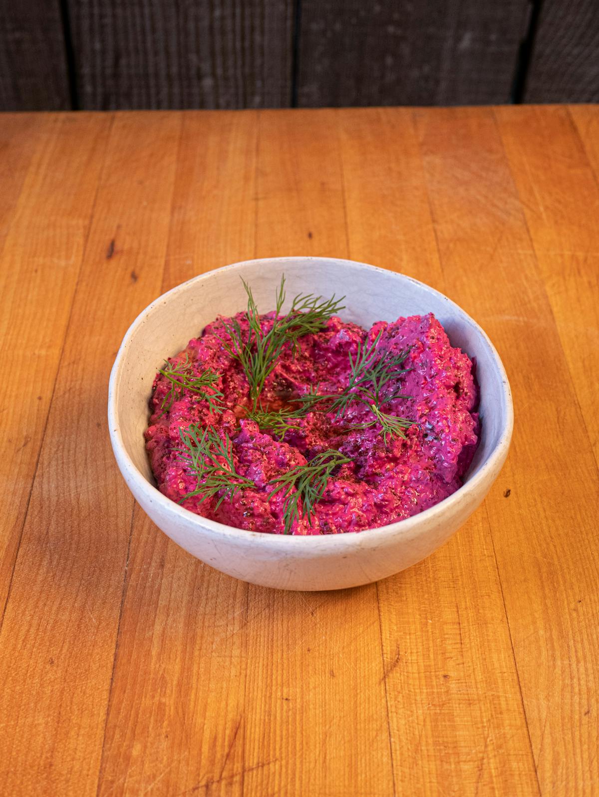 a bowl of fruit sitting on top of a wooden table
