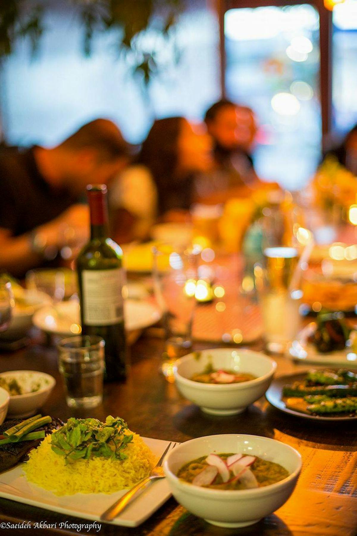 a person sitting at a table with food and drinks