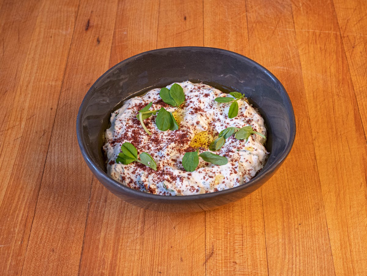 a bowl of food sitting on top of a wooden table