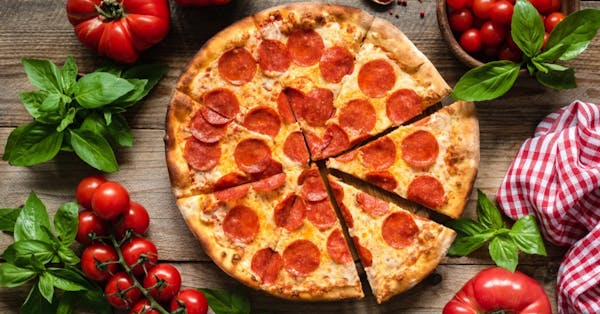 a pizza sitting on top of a wooden table