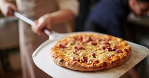 a pizza sitting on top of a wooden cutting board