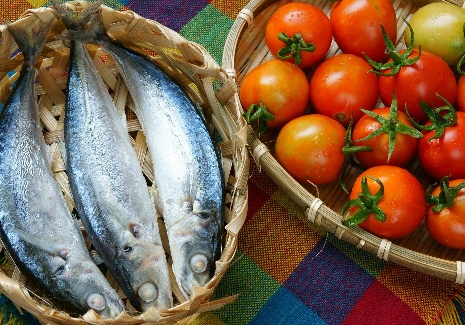 Baskets of fresh fish and tomatoes to represent French cuisine in French Polynesia and Vietnam.