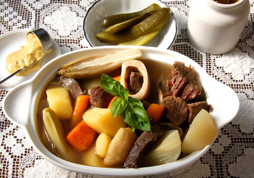 meat, potatoes, and vegetables in a bowl of broth