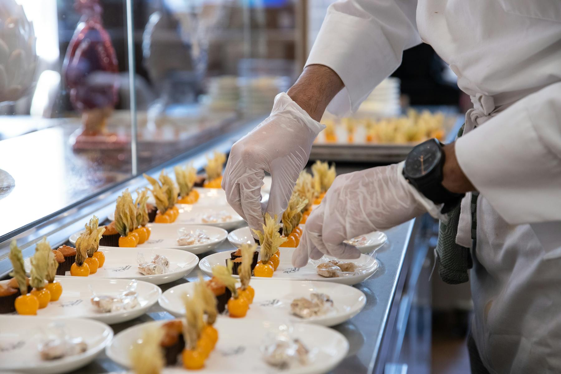 Chef preparing food on plates at the Bocuse Restaurant at the CIA in the Hudson Valley.