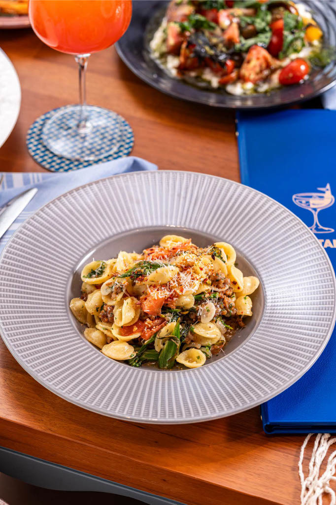 a plate of pasta with cheese and vegetables