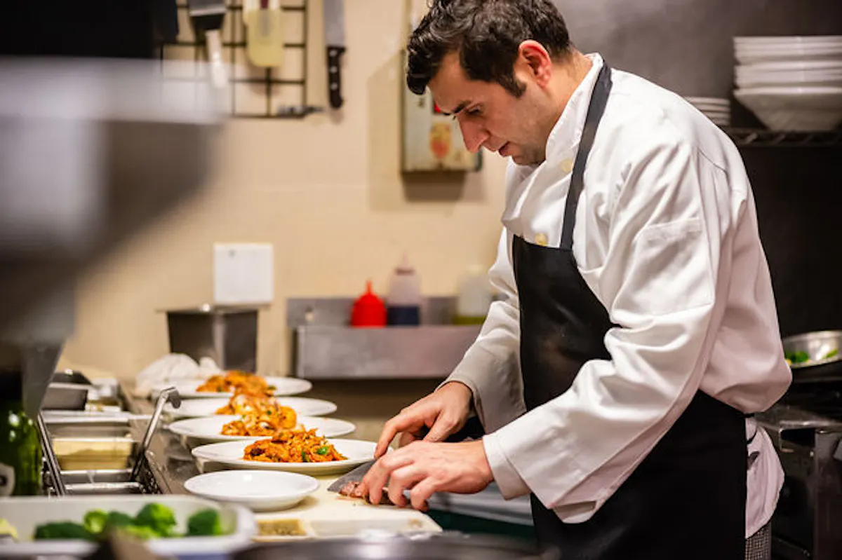 a man cooking in a kitchen preparing food