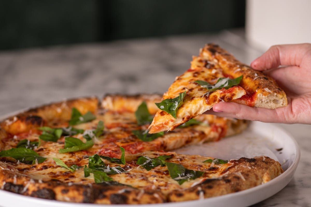 wood fired pizza on a round white plate