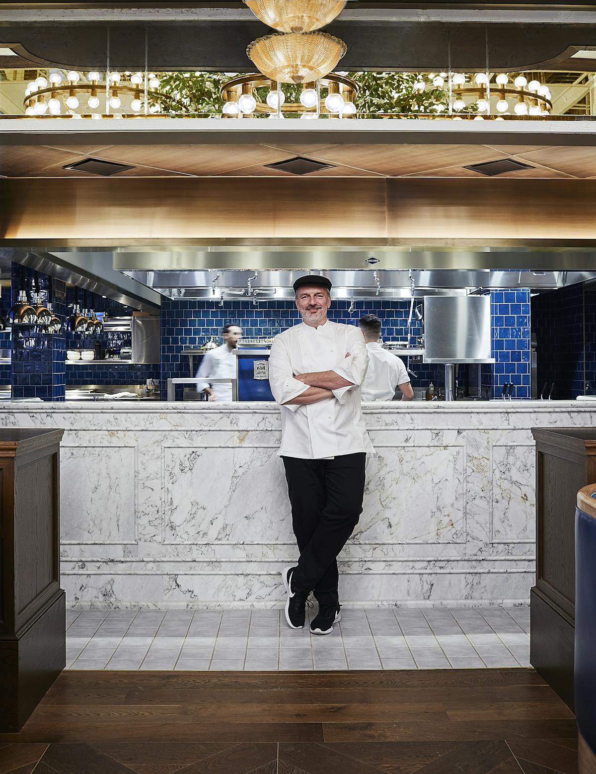 Andrew Carmellini that is standing in the kitchen