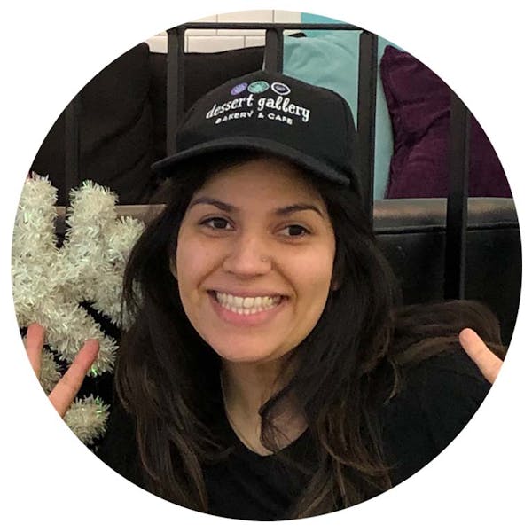 a woman wearing a hat and smiling at the camera