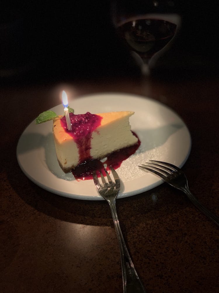 a plate with a birthday cake with lit candles