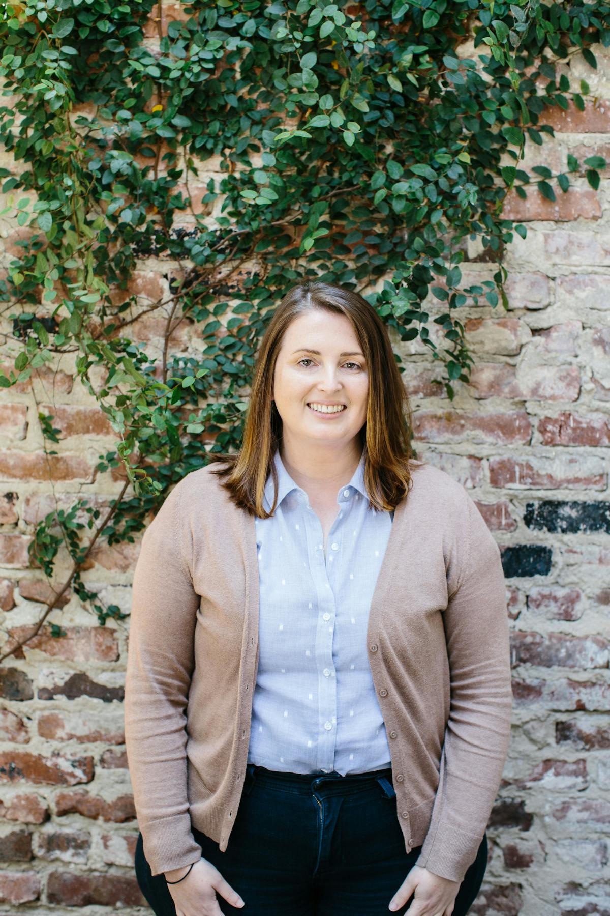 a person standing in front of a brick wall