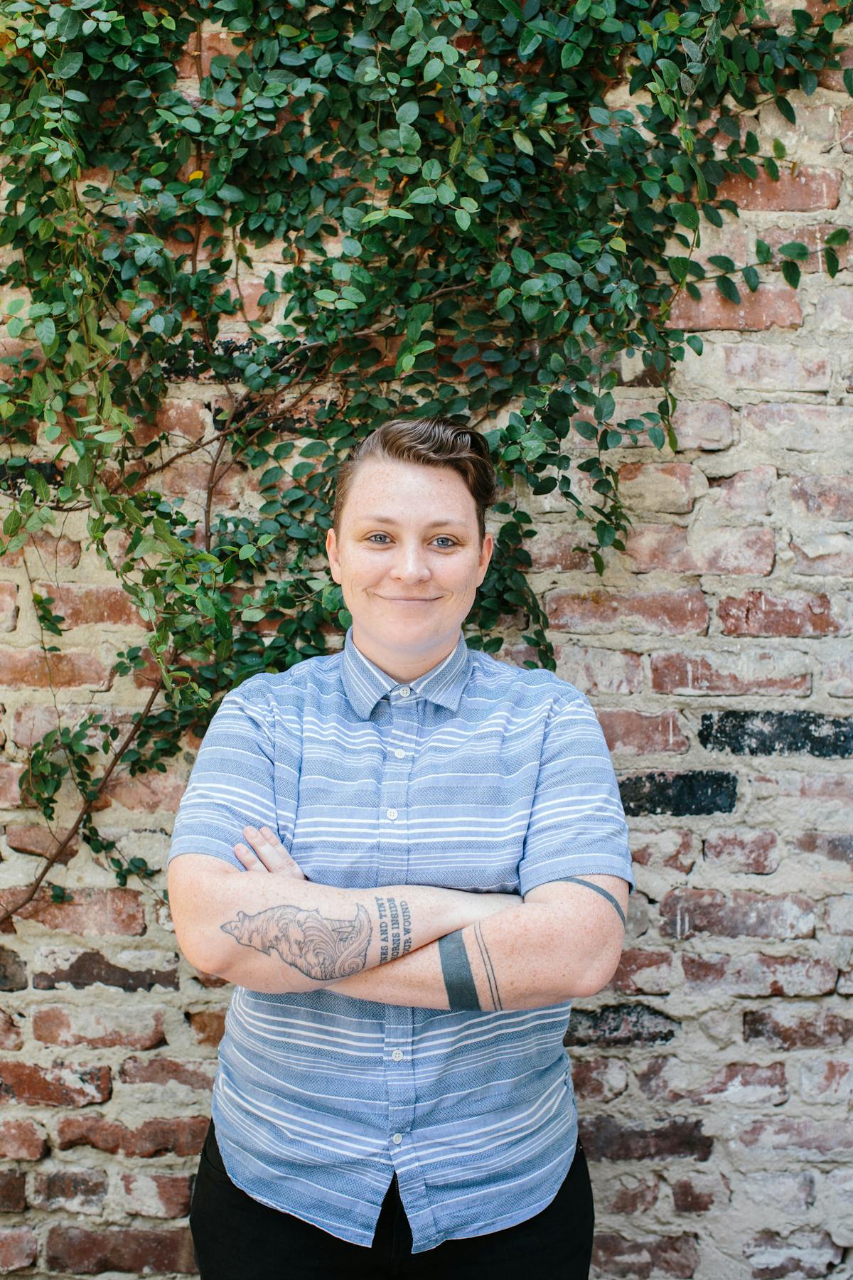 a person standing in front of a brick wall