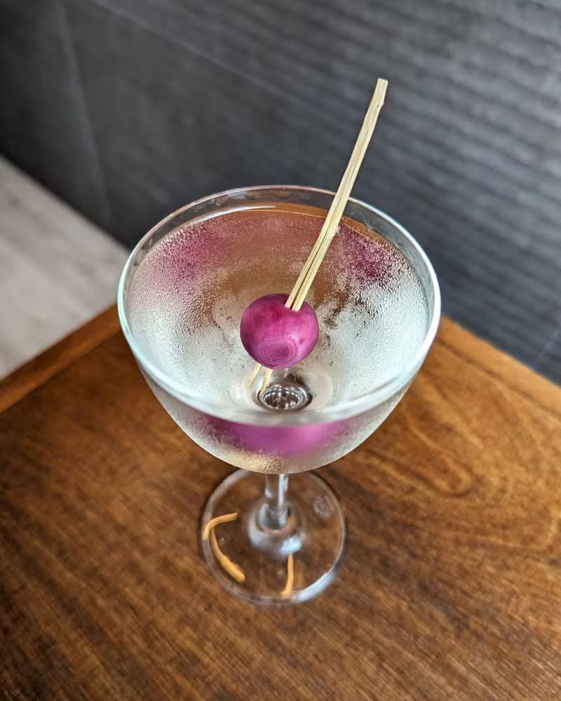 a glass of wine sitting on top of a wooden table