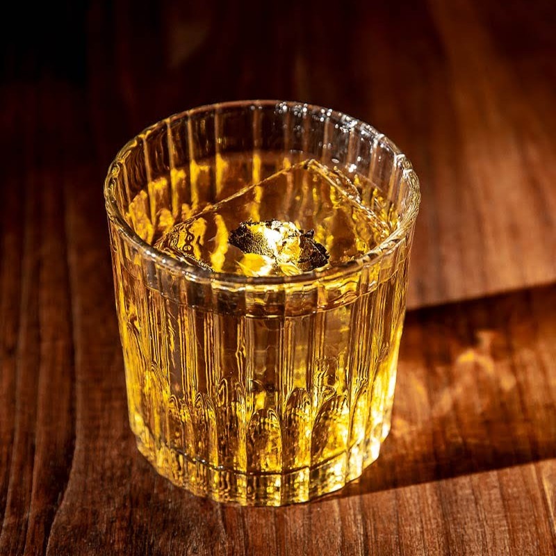 a glass of wine sitting on top of a wooden table