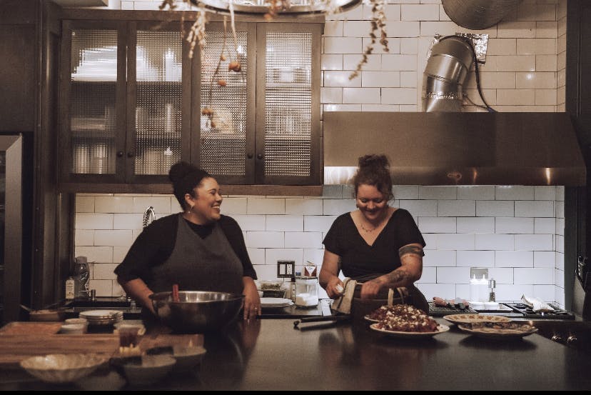 a man and woman preparing food in a kitchen