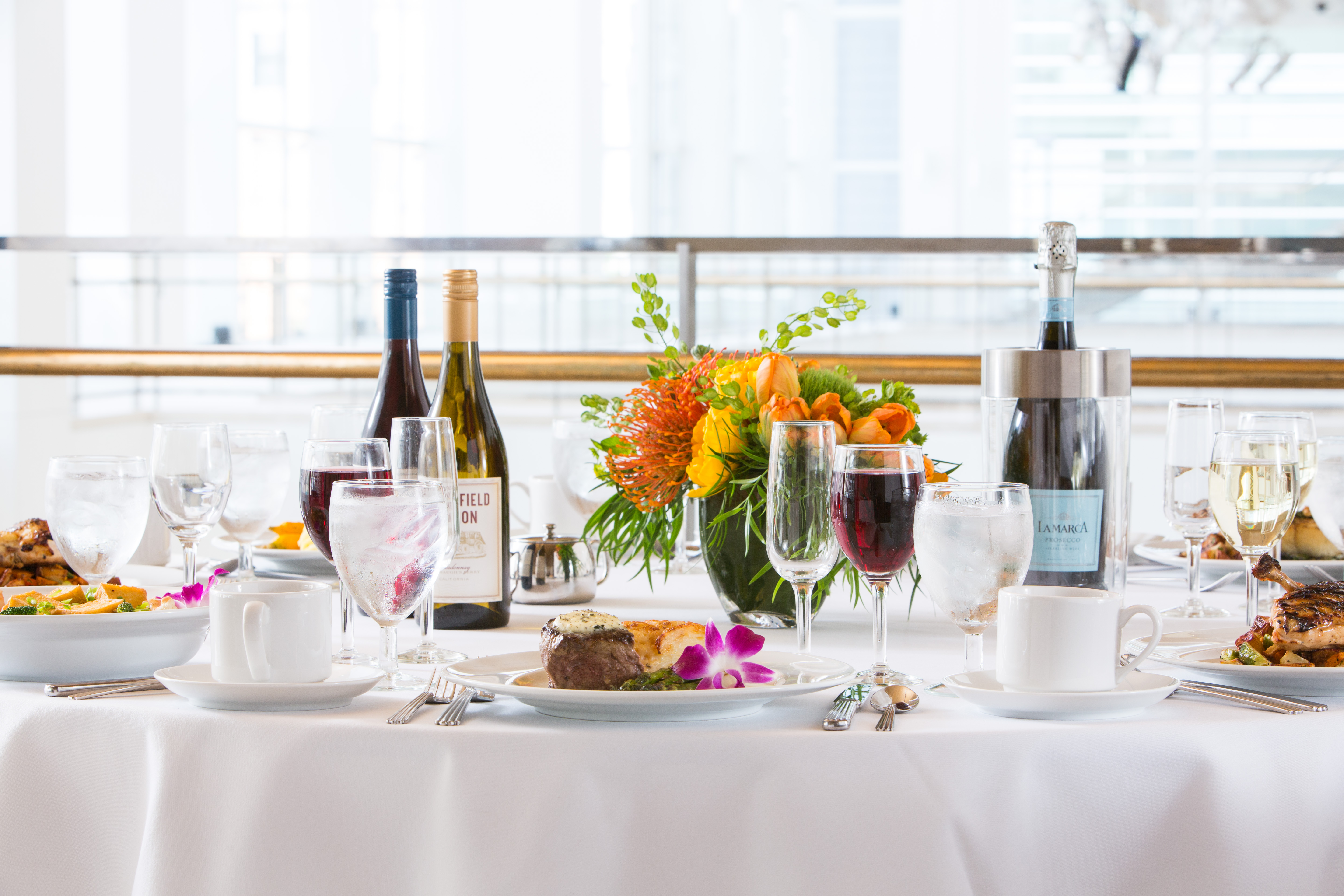 a person sitting at a table with wine glasses