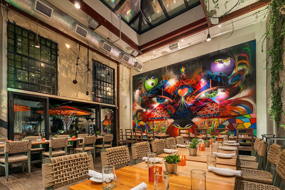 a restaurant dining room with a drawing as a background