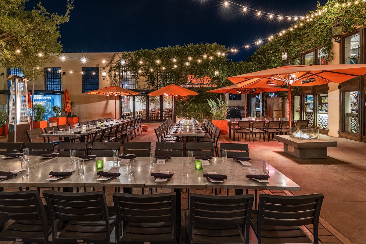 a group of people sitting at a table in front of a building