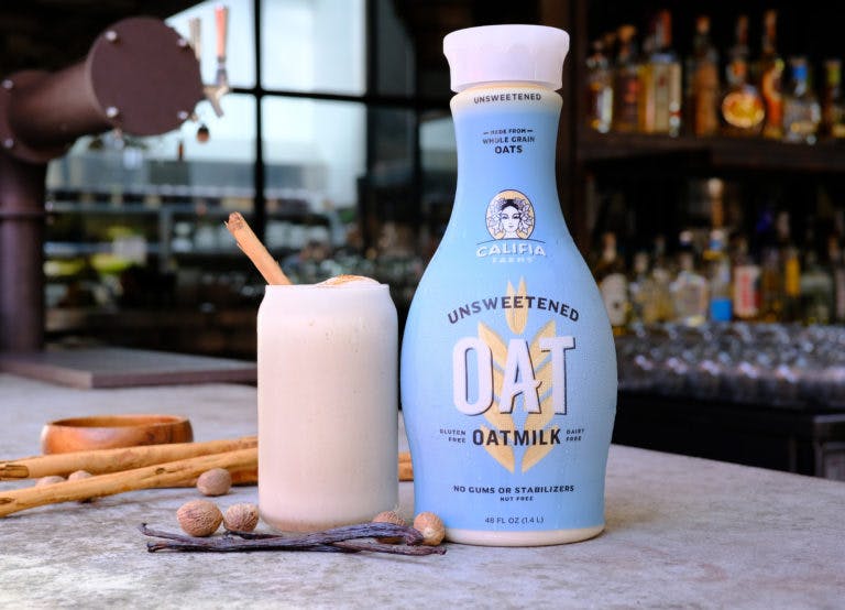 a close up of a bottle and a glass of milk on a counter