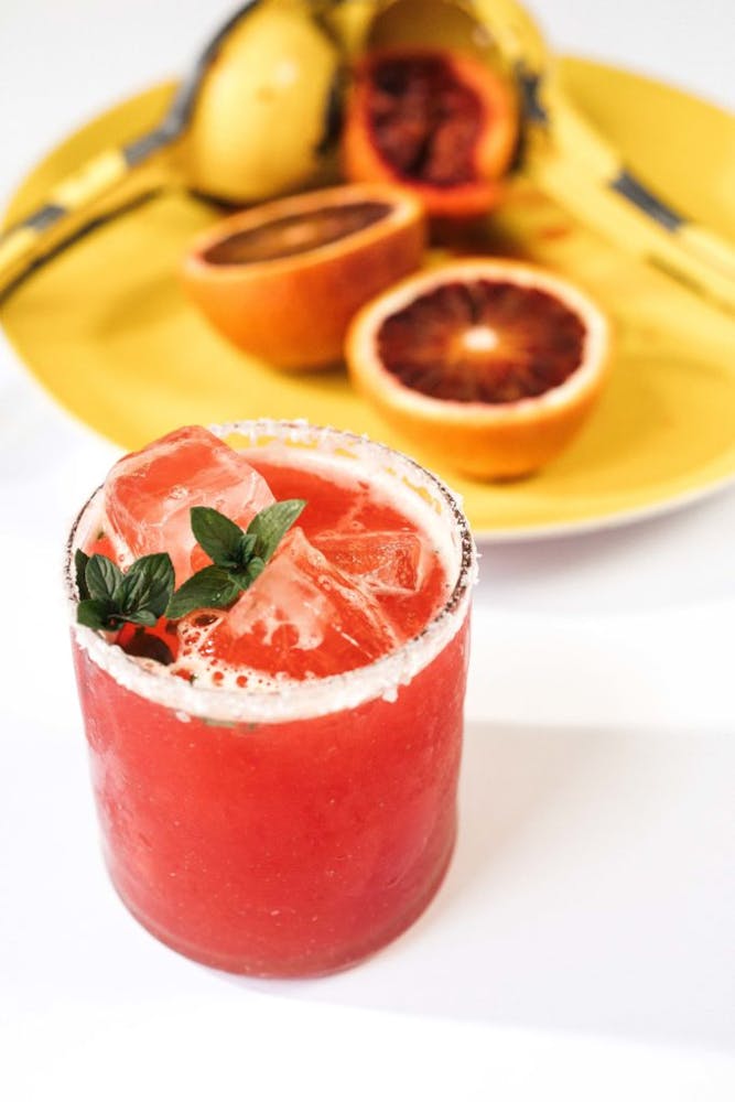 a close up on a drink and plate of fruits