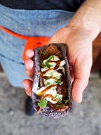 a hand holding a taco