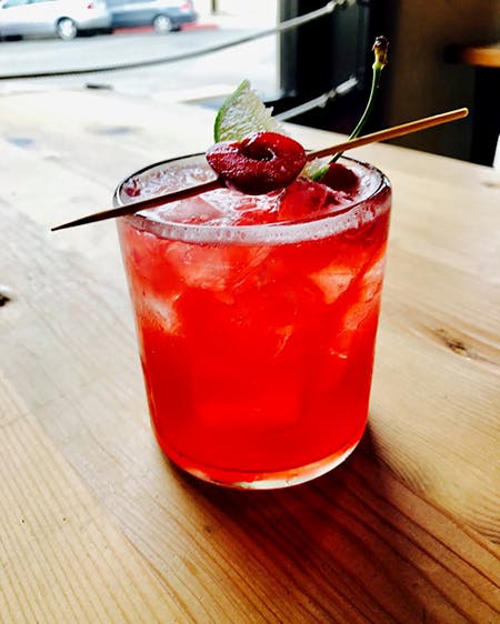a red drink sitting on top of a wooden table