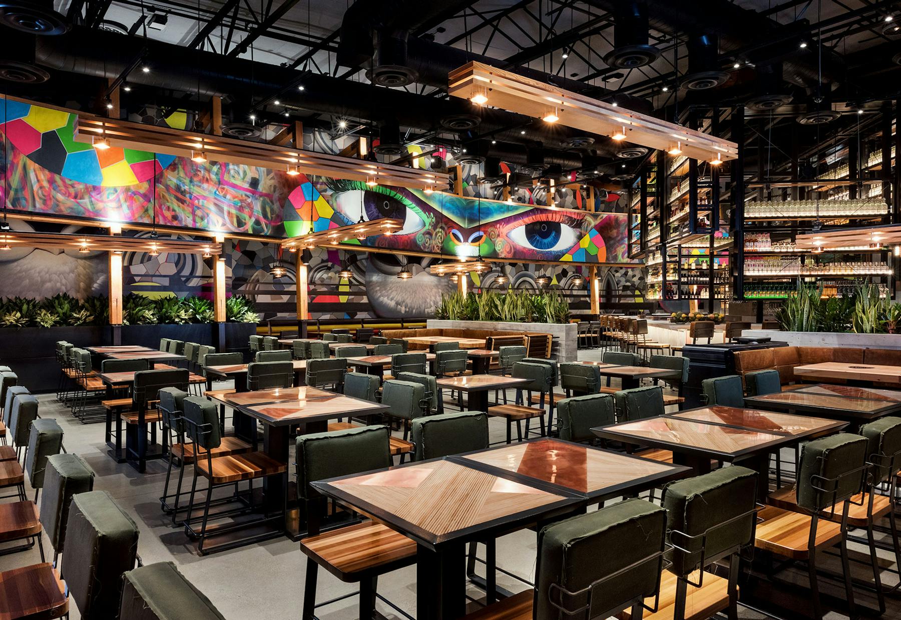 a restaurant dining room with a drawing as a background
