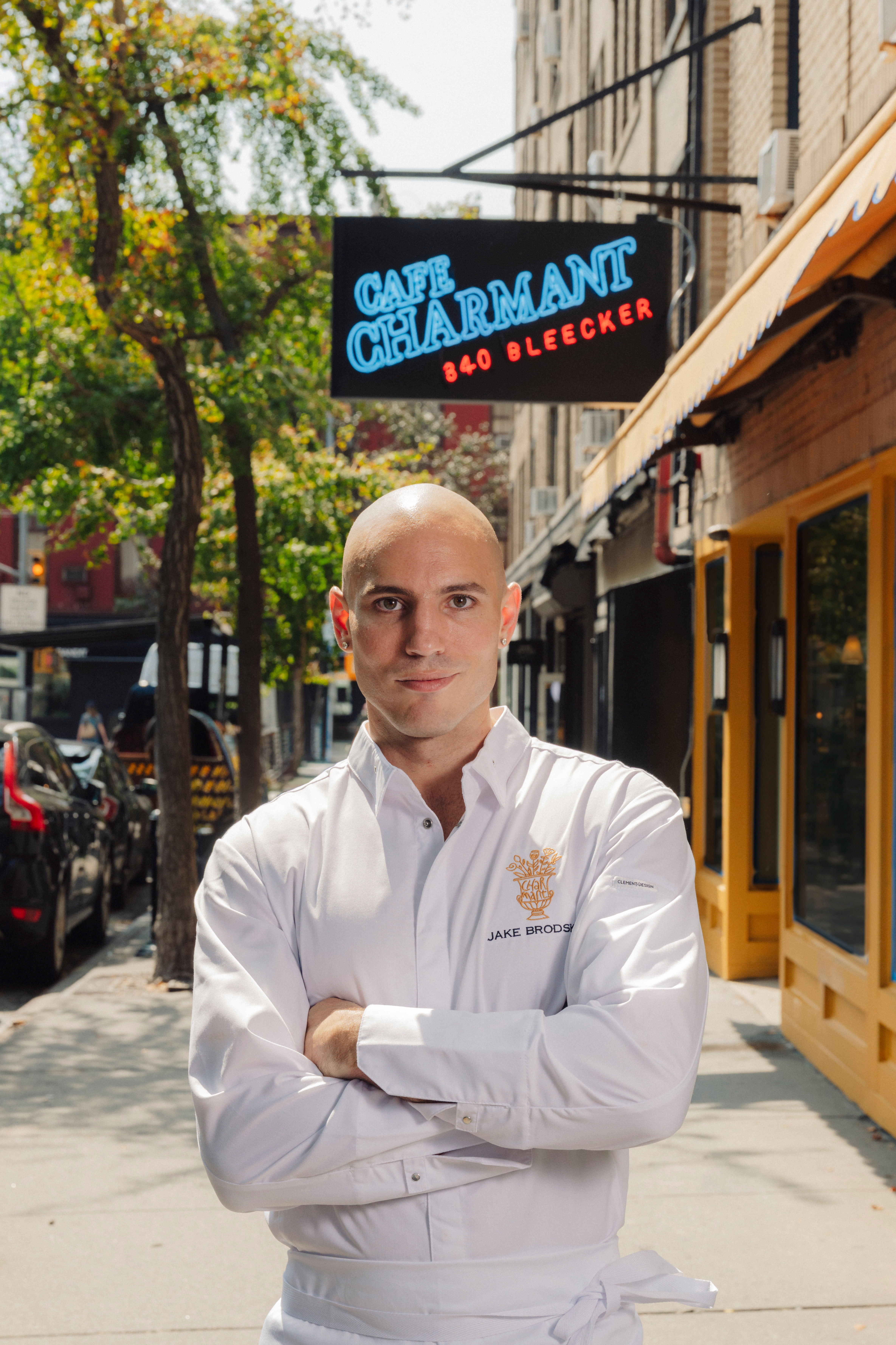 a man standing on a sidewalk with his arms crossed