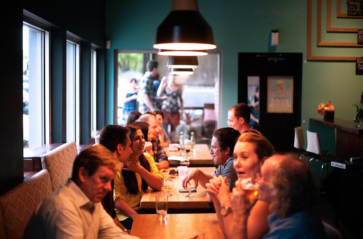 a group of people sitting at a table in a restaurant