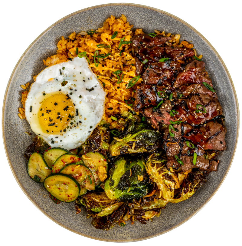 Pacific Catch Korean BBQ Bowl with grilled steak, kimchi fried rice, crispy Brussels sprouts, cucumber salad and a fried egg.