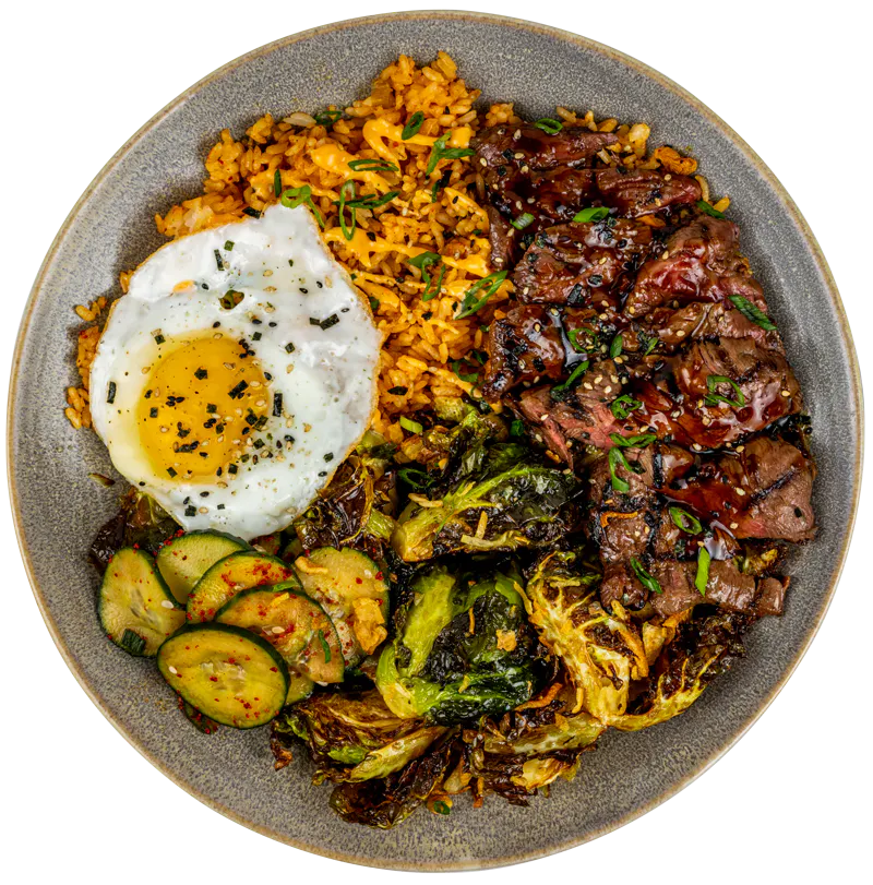 Pacific Catch Korean BBQ Bowl with grilled steak, kimchi fried rice, crispy Brussels sprouts, cucumber salad and a fried egg.